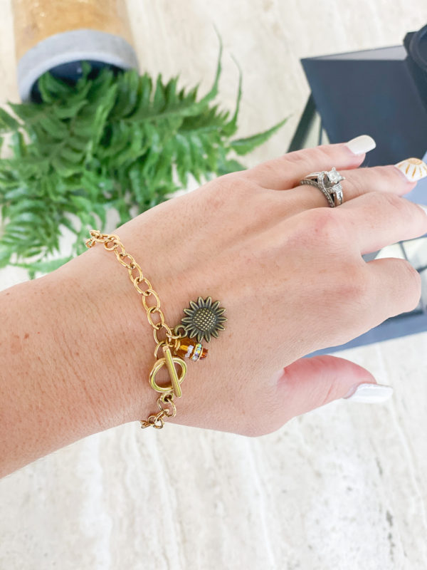 gold sunflower bracelet on woman's wrist